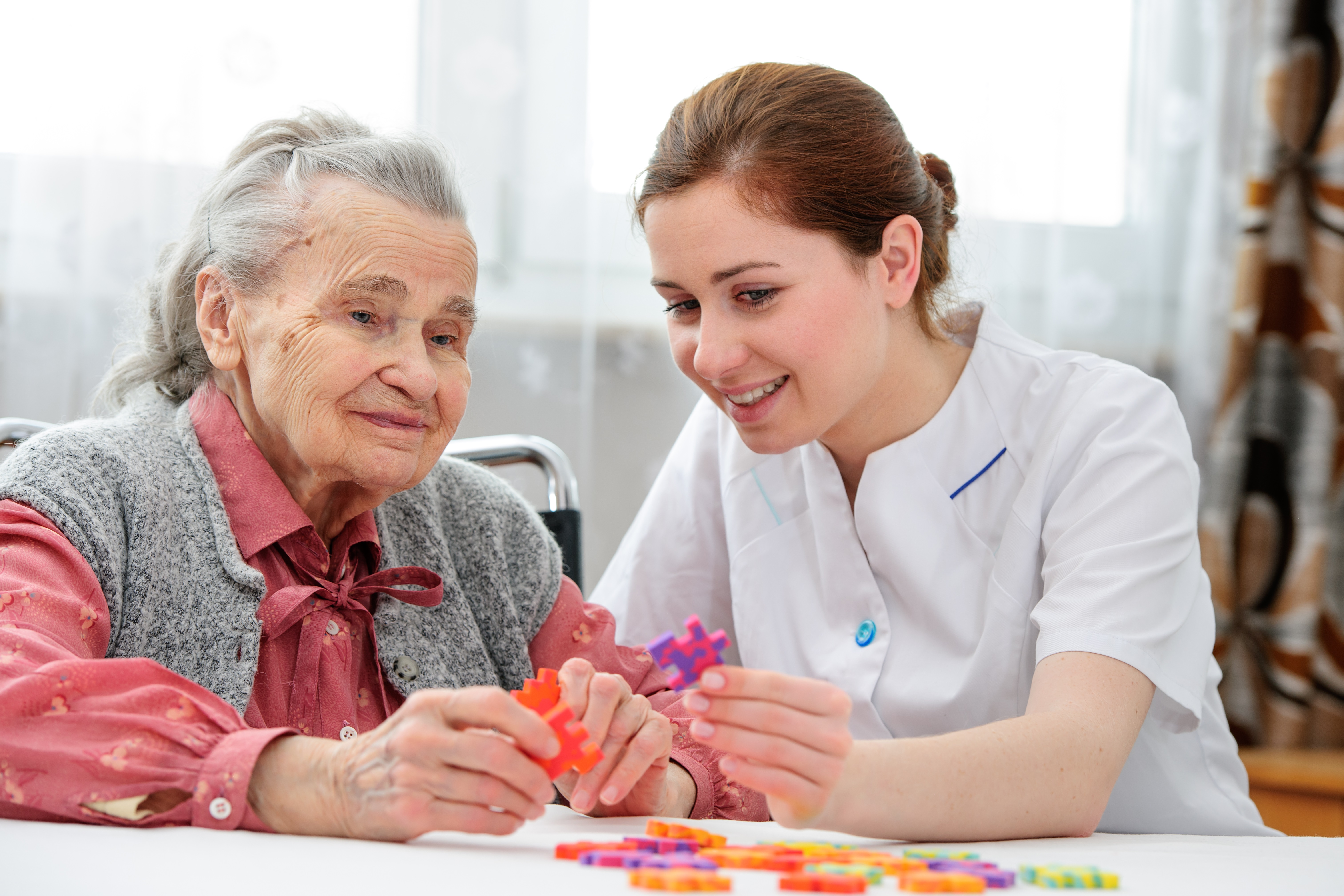 Aged Care worker with client playing a puzzle